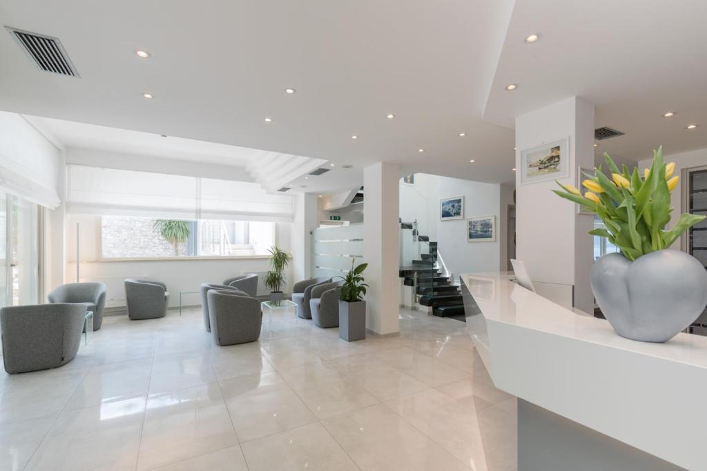 un hall avec des chaises et un vase de fleurs dans l'établissement Hotel Vega, à Malcesine 138 autres photos