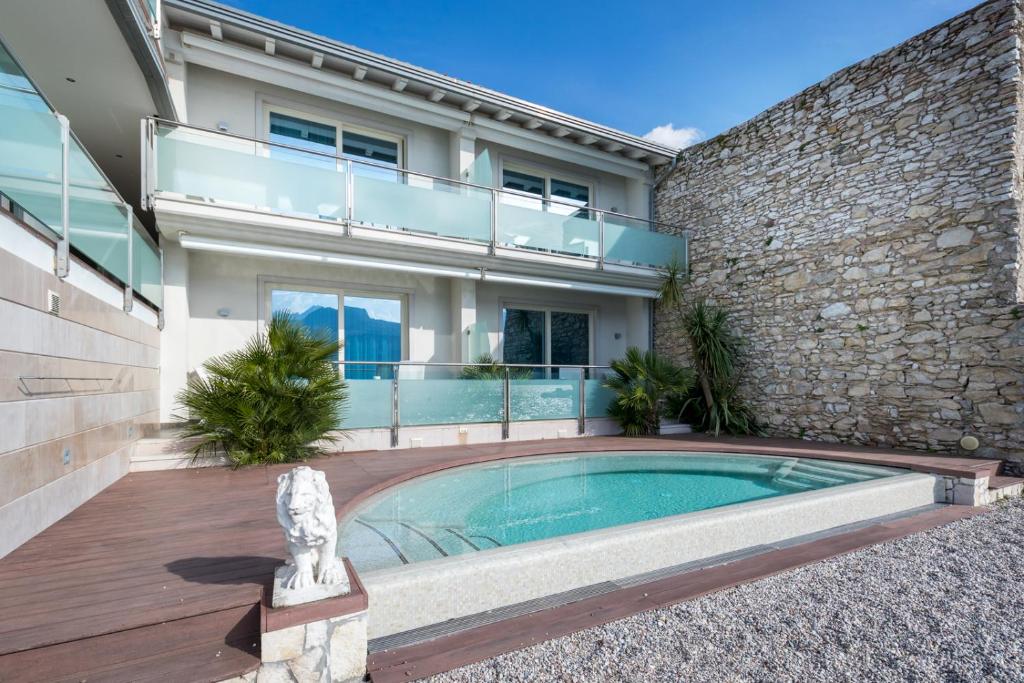 une maison avec piscine devant un immeuble dans l'établissement Hotel Vega, à Malcesine