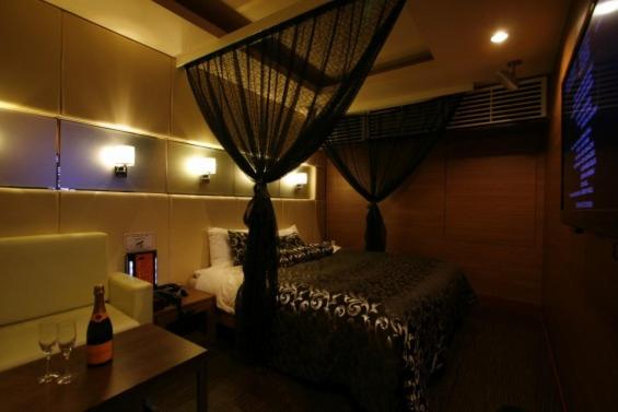 - une chambre avec un lit et une table avec des verres à vin dans l'établissement ホテルパシオン, à Hamano