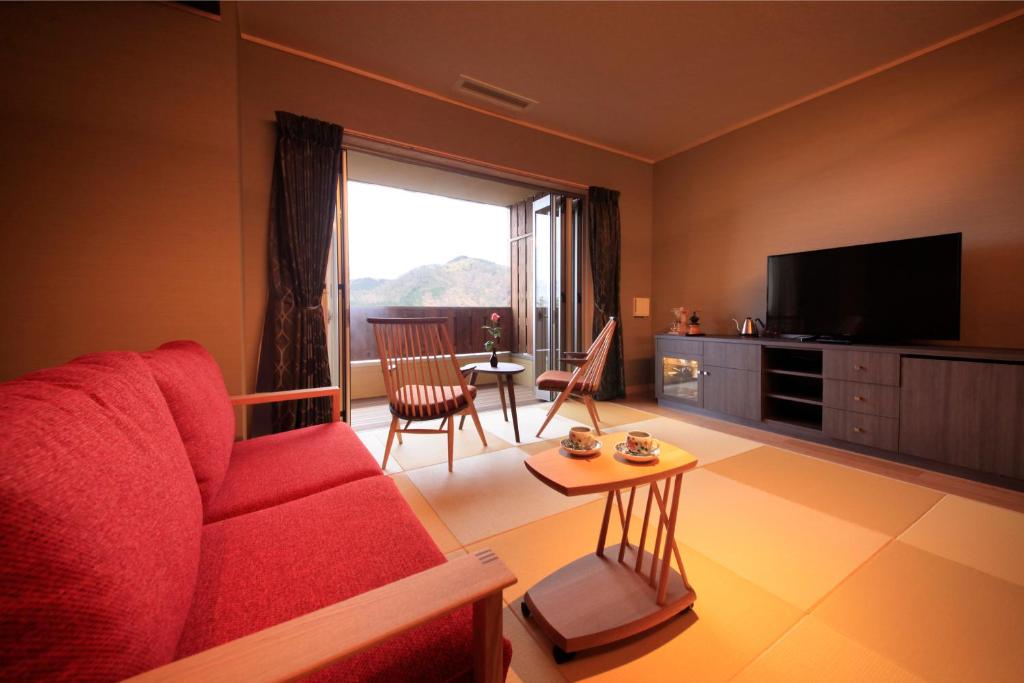 un salon avec un canapé rouge et une télévision dans l'établissement Tensui Saryo, à Hakone