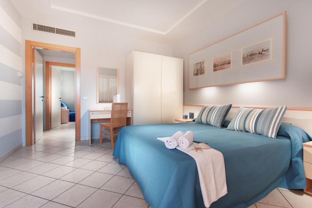 une chambre avec un lit bleu avec des serviettes dessus dans l'établissement Hotel Sport & Residenza, à Cesenatico