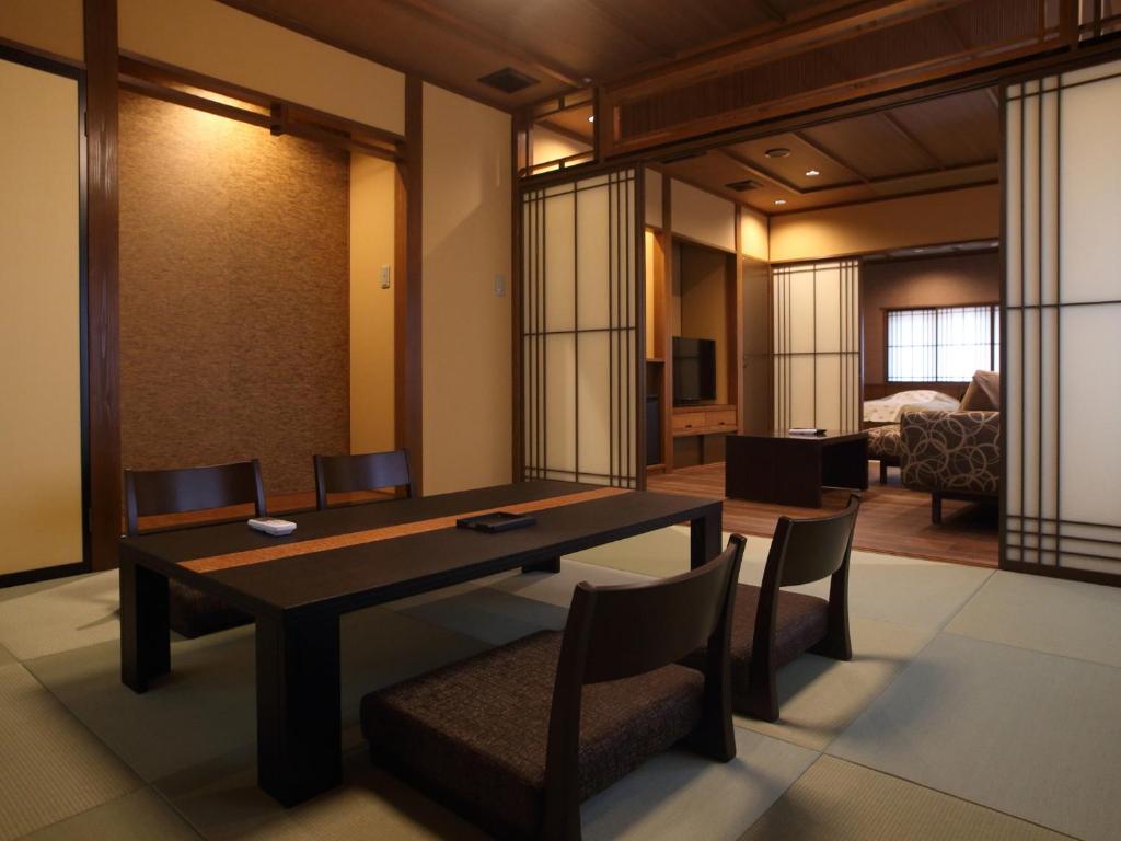 une salle à manger avec une table et des chaises et une chambre dans l'établissement Kanazawa Yuwaku Onsen Kokarian, à Kanazawa