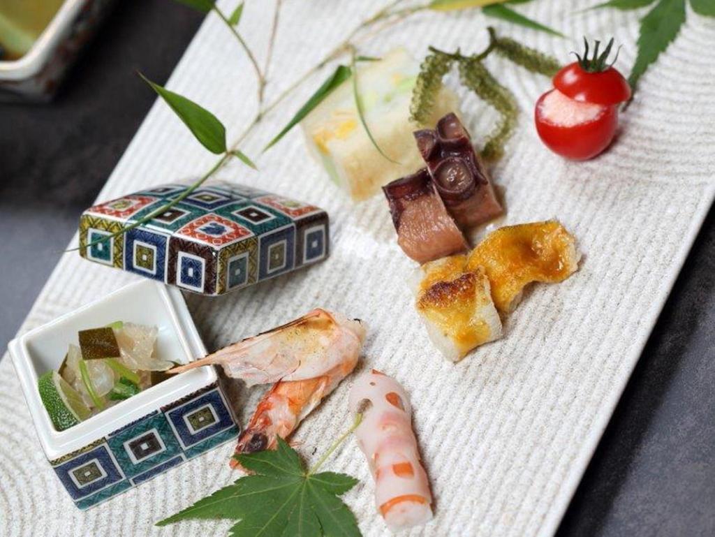 une assiette de nourriture avec des sushis et d'autres aliments dans l'établissement Kanazawa Yuwaku Onsen Kokarian, à Kanazawa