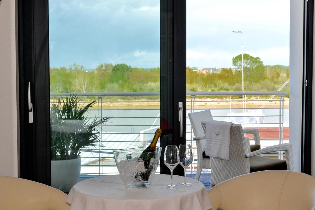 une table avec deux verres de vin sur un balcon dans l'établissement Stay Michelangelo Jesolo Only Adults, à Lido di Jesolo