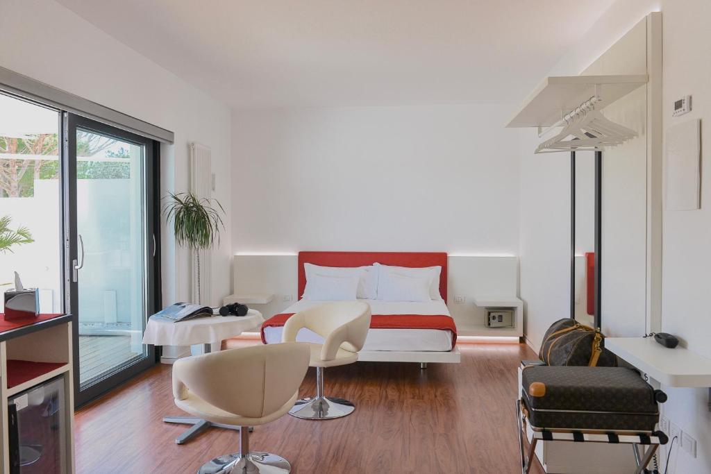 une chambre avec un lit, une table et des chaises dans l'établissement Stay Michelangelo Jesolo Only Adults, à Lido di Jesolo