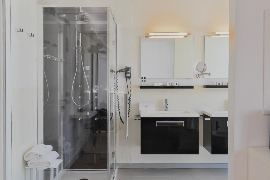 une salle de bain blanche avec une douche et un lavabo dans l'établissement Stay Michelangelo Jesolo Only Adults, à Lido di Jesolo