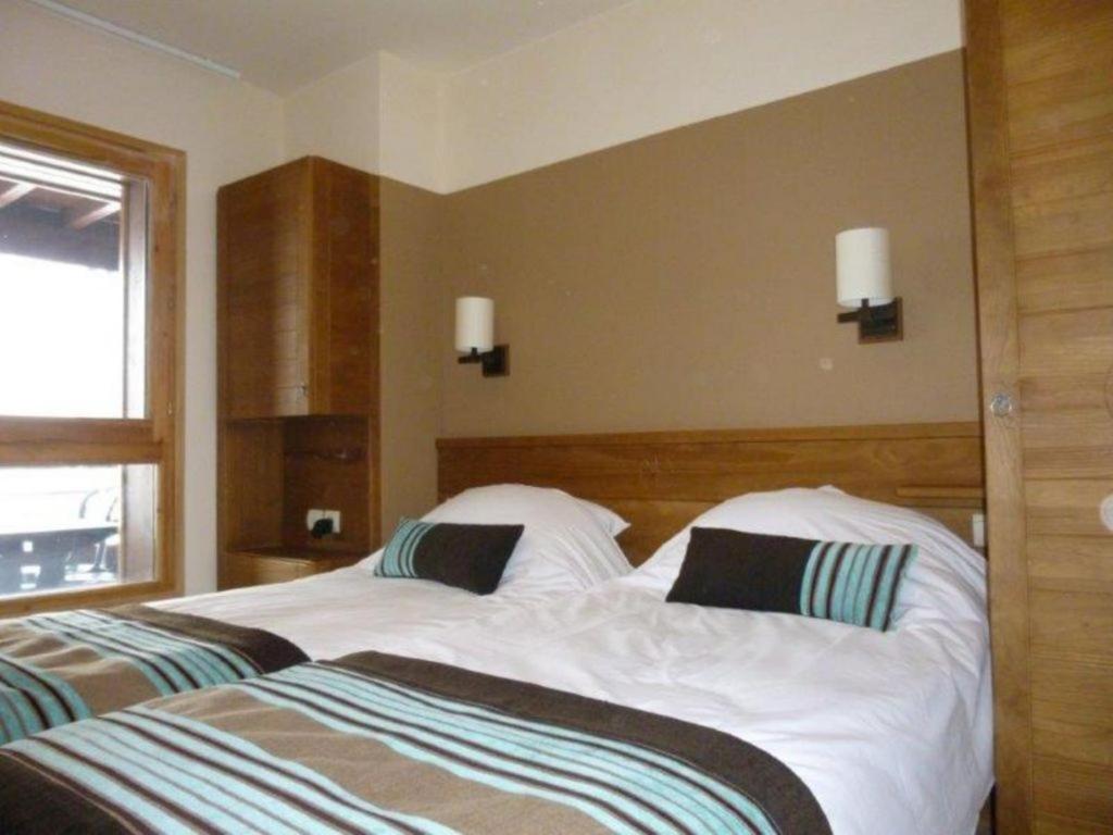 une chambre avec deux lits blancs et une fenêtre dans l'établissement Flaine prime ski in, ski out Apartment, à Flaine