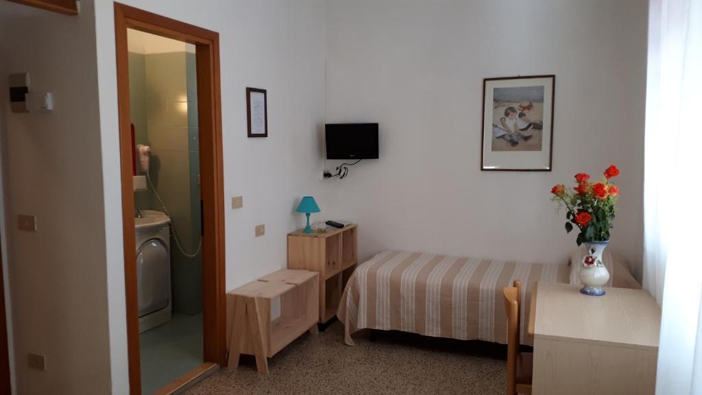 une petite chambre avec un lit et un miroir dans l'établissement Hotel Villa Dina, à Lido di Jesolo