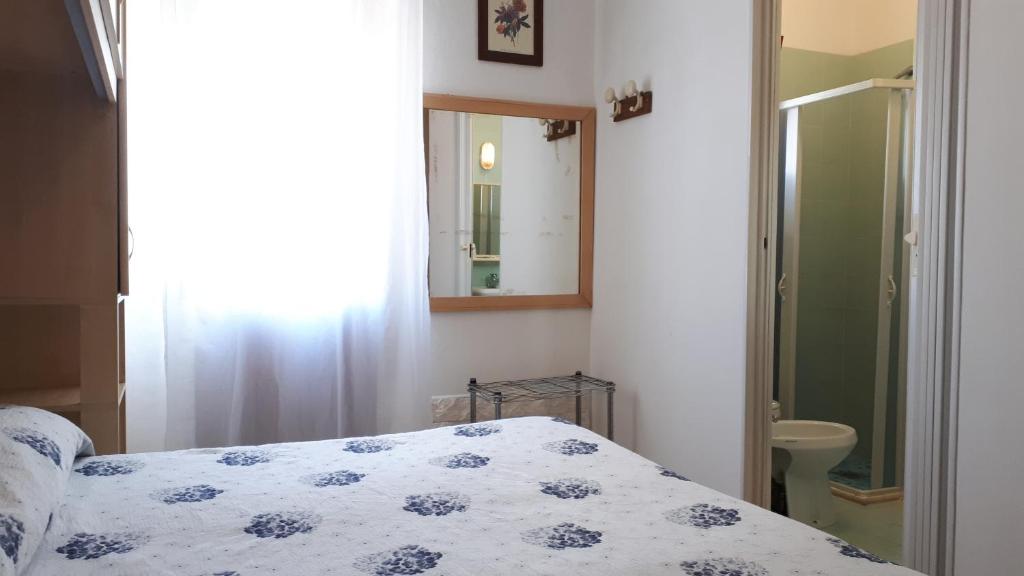 une chambre avec un lit et un miroir dans l'établissement Hotel Villa Dina, à Lido di Jesolo