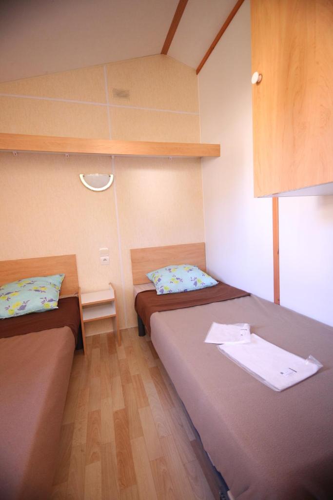 Cette petite chambre comprend 2 lits. dans l'établissement Camping Le Ruisseau, à Saint-André-de-Seignanx