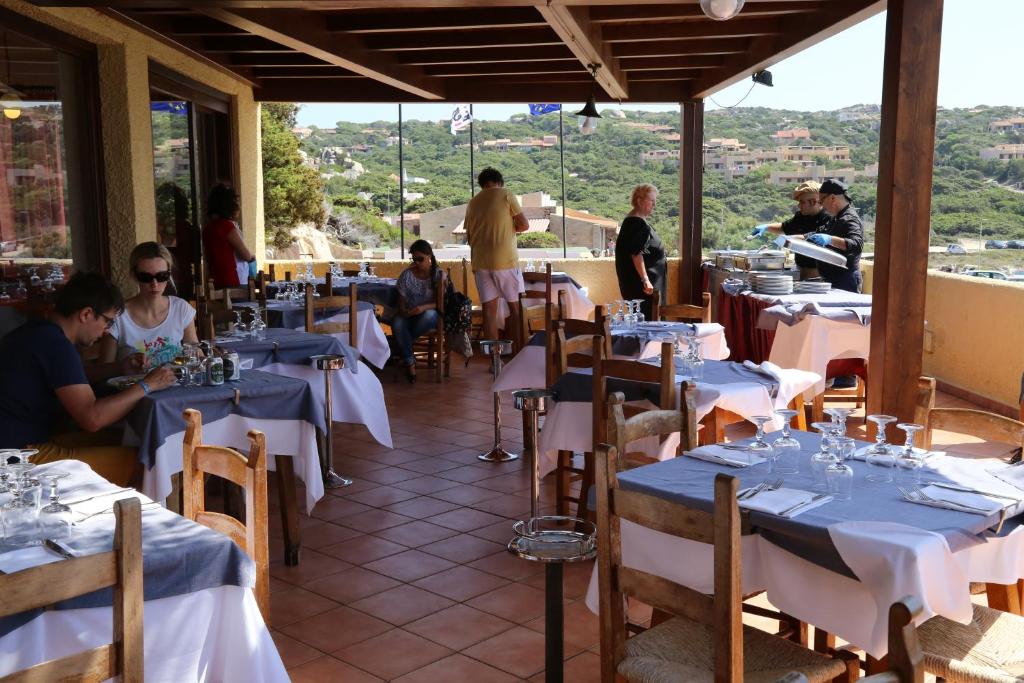 un restaurant avec des tables et des gens assis à des tables dans l'établissement Club Esse Shardana, à Santa Teresa Gallura