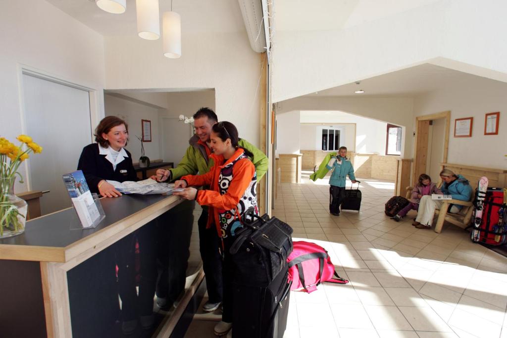 un groupe de personnes debout au comptoir avec bagages dans l'établissement Résidence Pierre & Vacances Antarès, à Avoriaz