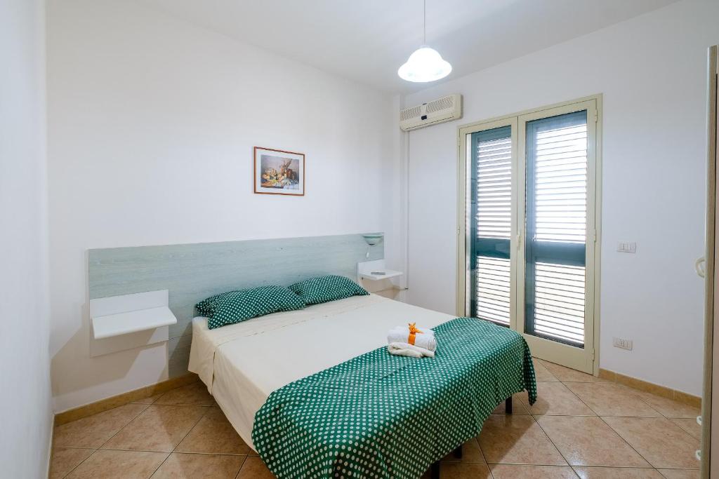 une chambre blanche avec un lit et une fenêtre dans l'établissement Residenza Arene, à Gallipoli