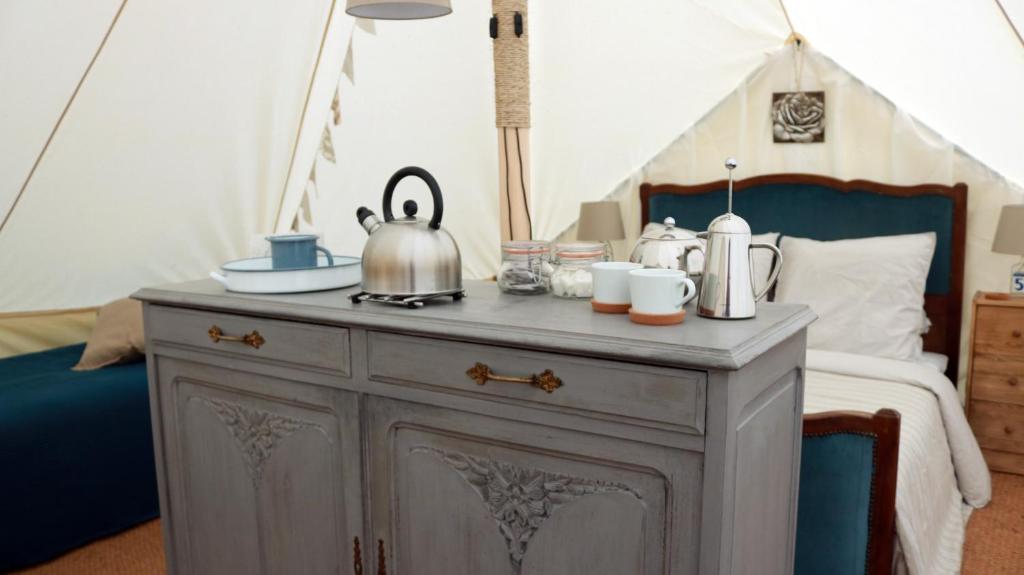 - une table avec une bouilloire au-dessus d'un lit dans l'établissement La Toile sous Les Étoiles, à Charron
