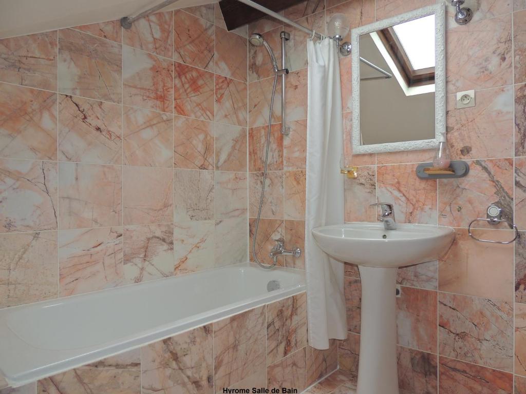 une salle de bain avec un lavabo, une baignoire et un miroir dans l'établissement Gîte Hyrom 5 Places Moulin de la Placette, à Faye-d'Anjou