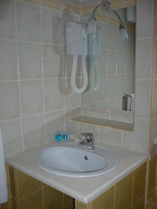 une salle de bain avec un lavabo blanc et un miroir dans l'établissement Hotel Ristorante Antica Marina, à Nicotera Marina