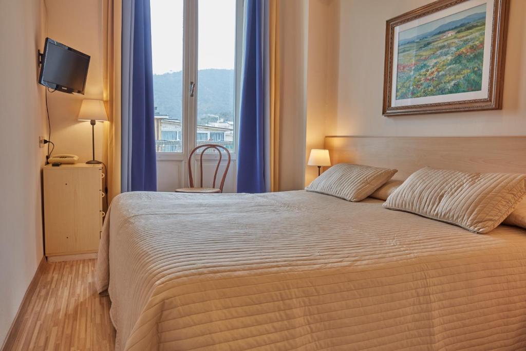 une chambre avec un grand lit et une fenêtre dans l'établissement Albergo Celeste, à Sestri Levante