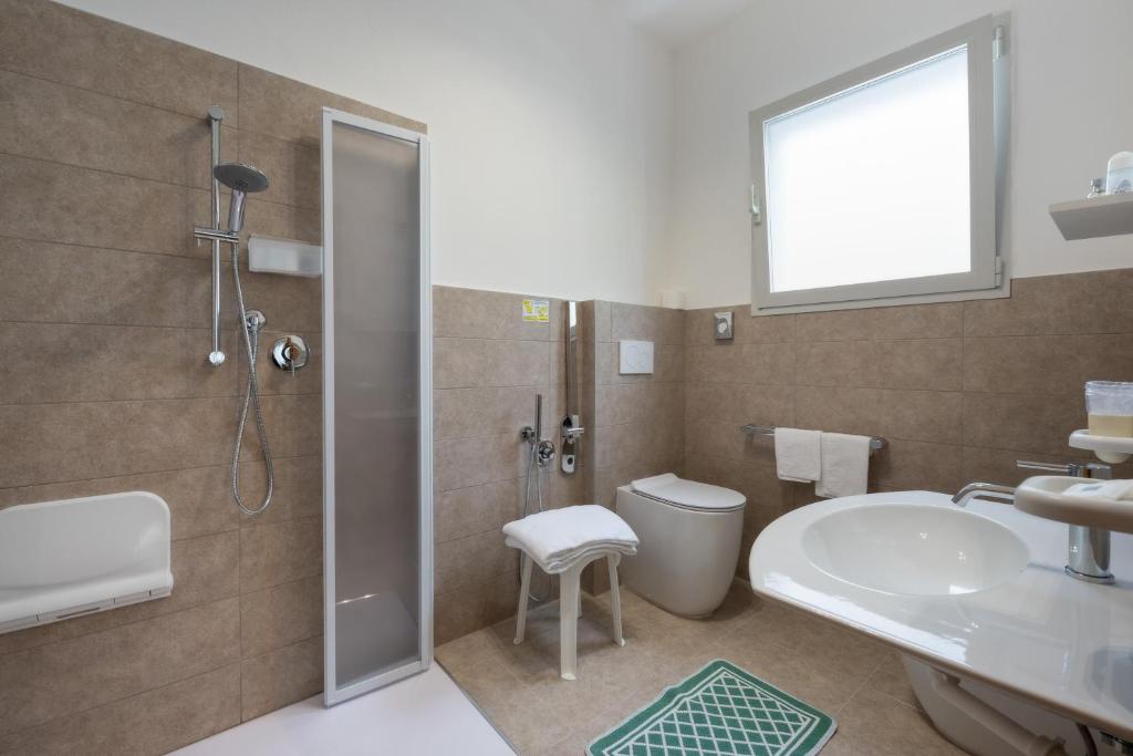 une salle de bain avec douche, lavabo et toilettes dans l'établissement Hotel Fabris, à Caorle 24 autres photos
