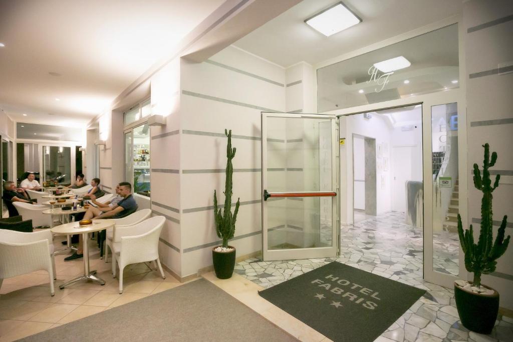 une salle avec des gens assis à des tables dans un restaurant dans l'établissement Hotel Fabris, à Caorle