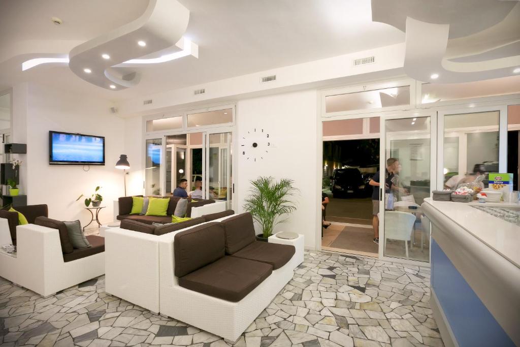 un salon avec deux canapés et une télévision dans l'établissement Hotel Fabris, à Caorle