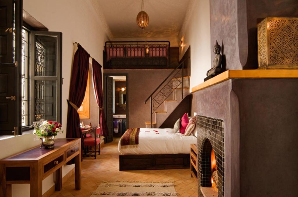 une chambre avec un lit et une cheminée dans l'établissement Riad Cinnamon by Marrakech Riad, à Marrakech