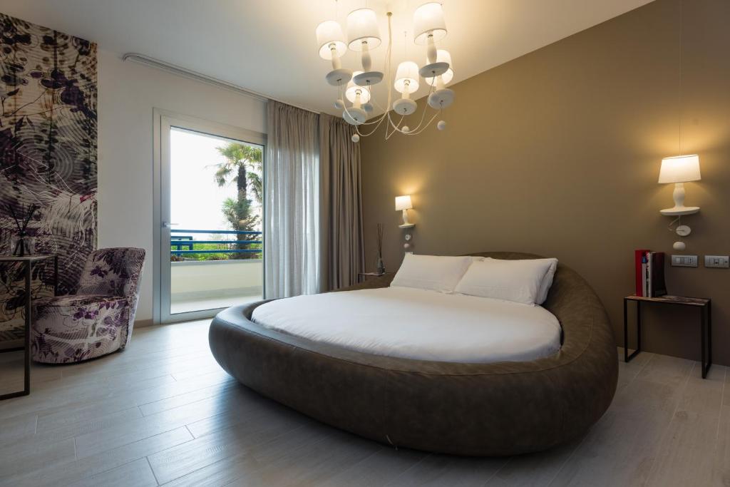 - une chambre avec un grand lit et un grand pouf dans l'établissement Bibione Palace Hotel, à Bibione 52 autres photos