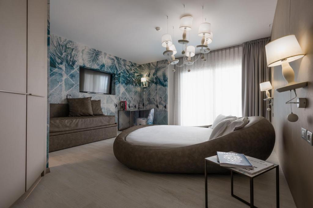 une chambre avec un grand lit et un canapé dans l'établissement Bibione Palace Hotel, à Bibione