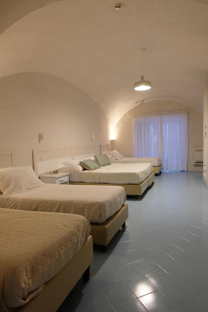 - un groupe de trois lits dans une chambre dans l'établissement Hotel Baia Di Puolo, à Massa Lubrense