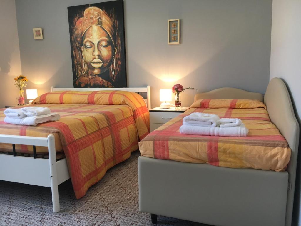 une chambre avec deux lits et un tableau au mur dans l'établissement Hotel Gianna, à Roseto degli Abruzzi