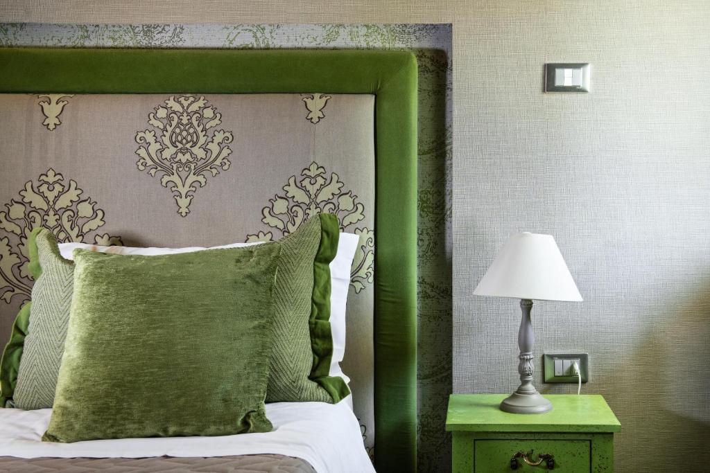 un lit vert avec une tête de lit verte et une lampe dans l'établissement Hotel Salus, à Pescara