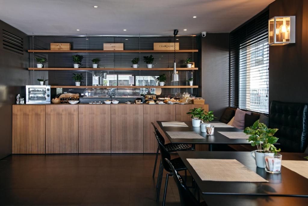 un restaurant avec des tables et une cuisine avec un comptoir dans l'établissement Hotel Salus, à Pescara