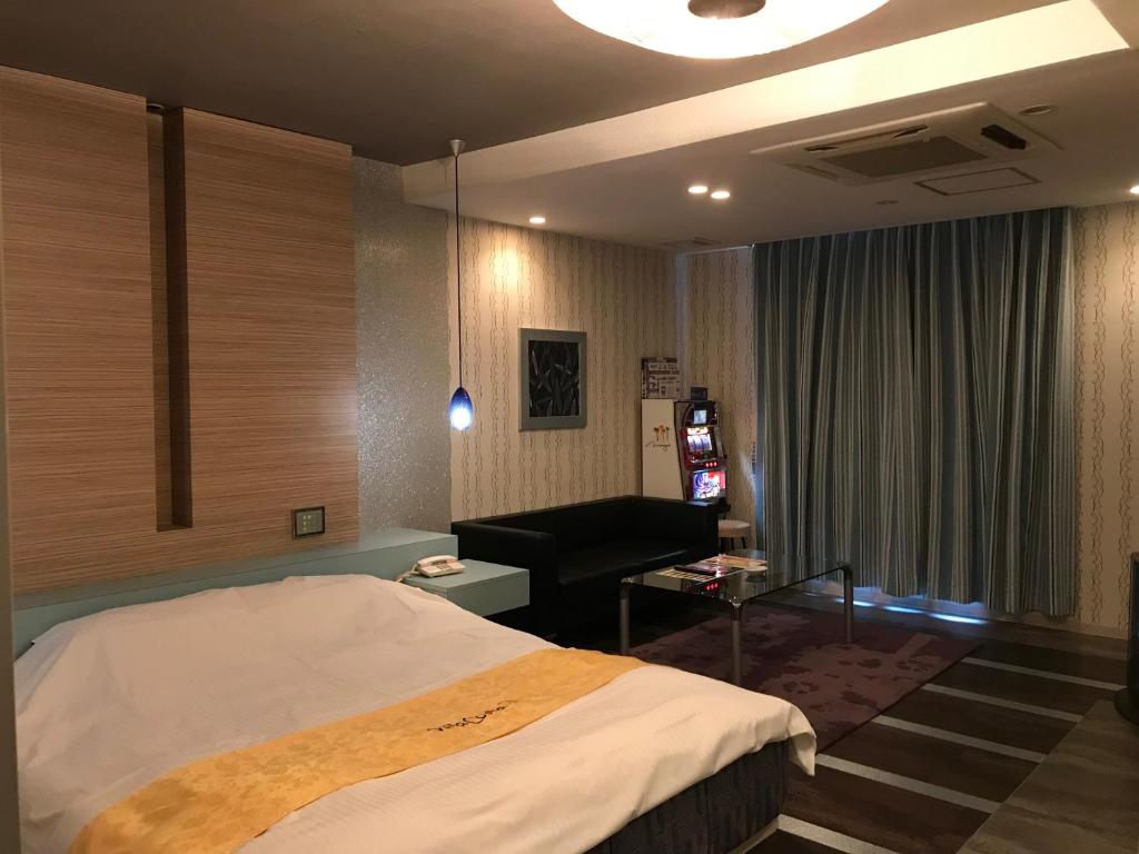 une chambre d'hôtel avec un lit et un canapé dans l'établissement ホテルヴィラコスタ Adult Only 男塾ホテルグループ, à Hikone 10 autres photos