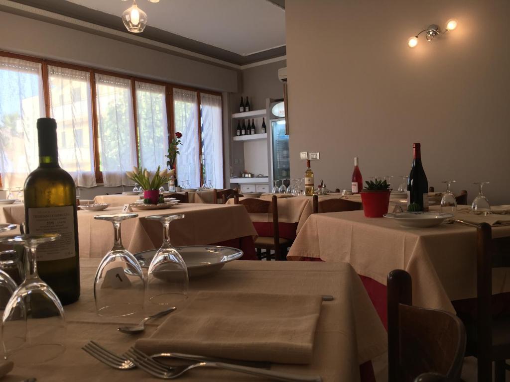 - une salle à manger avec des tables et des bouteilles de vin dans l'établissement Hotel Gianna, à Roseto degli Abruzzi