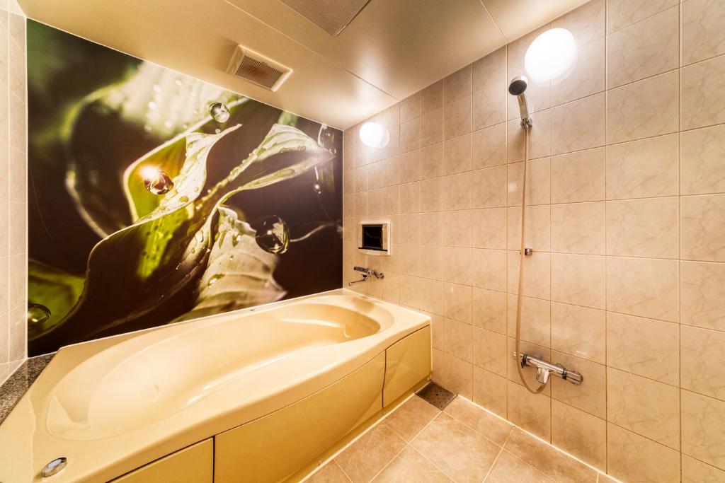 une salle de bain avec une baignoire et un tableau au mur dans l'établissement Hotel Lotus Otsu (Adult Only), à Ōtsu 29 autres photos