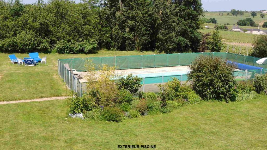un bâtiment avec une piscine dans un champ dans l'établissement Gîte Hyrom 5 Places Moulin de la Placette, à Faye-d'Anjou 3 autres photos