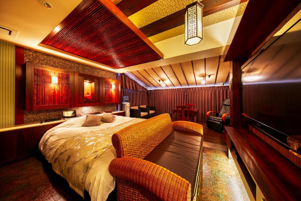- une chambre avec un lit et deux chaises dans l'établissement Hotel Lotus Otsu (Adult Only), à Ōtsu