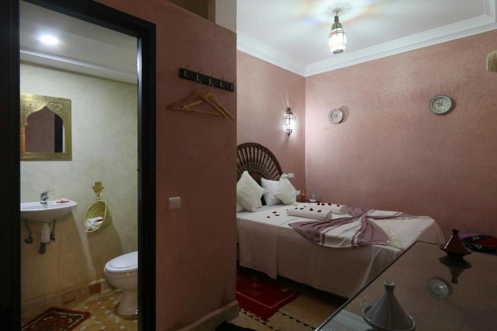 une chambre avec un lit et une salle de bain avec un lavabo dans l'établissement Riad Elite, à Marrakech