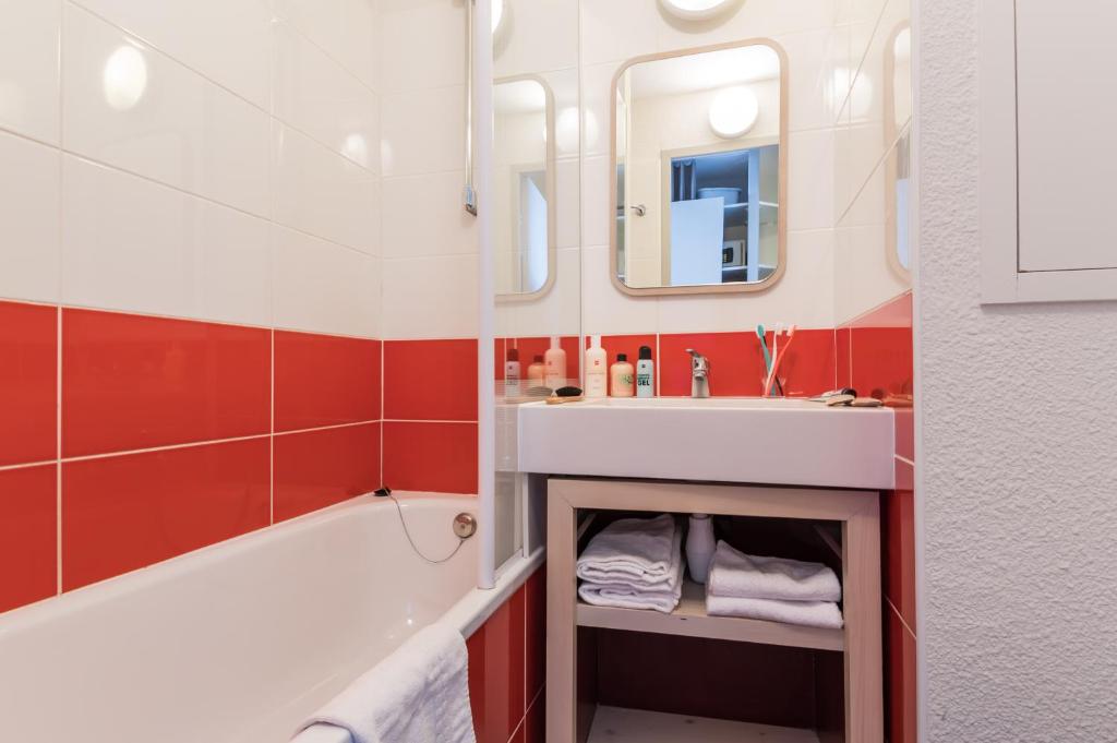 une salle de bain avec un lavabo, une baignoire et un miroir dans l'établissement Résidence Pierre & Vacances Antarès, à Avoriaz