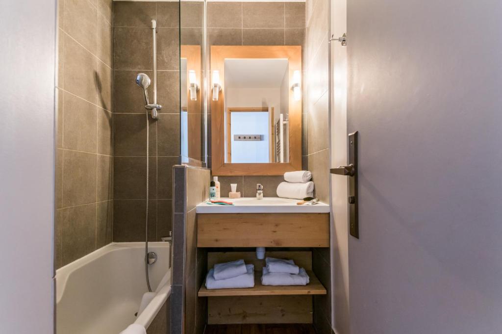une salle de bain avec un lavabo et une douche avec un miroir dans l'établissement Résidence Pierre & Vacances Les Néréides, à Belle Plagne