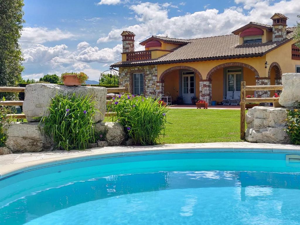 une maison avec une piscine devant une maison dans l'établissement Tuscan Villa exclusive use of private pool A/C Wifi Villa Briciola, à Capannori