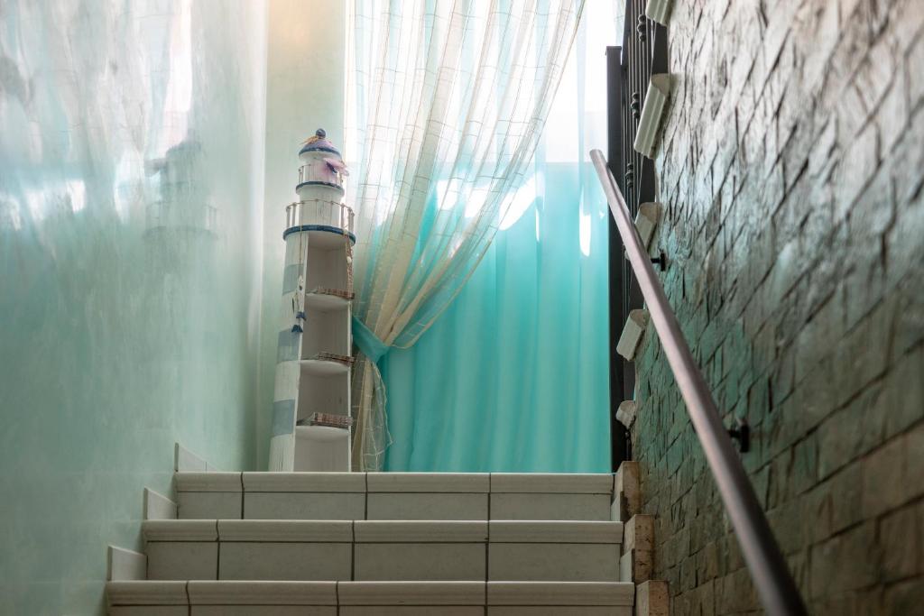 un escalier avec un phare sur le côté d'un bâtiment dans l'établissement Hotel Adigrat, à Riccione