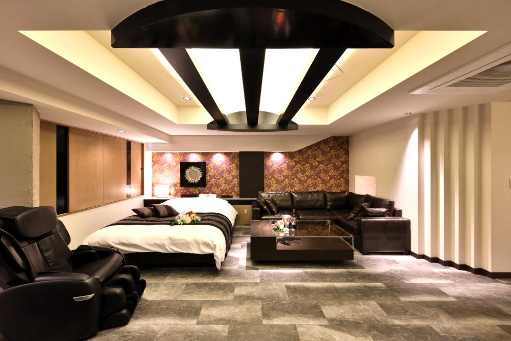 une chambre avec un lit, un canapé et des chaises dans l'établissement HOTEL MYTH-Y ホテル マイス ワイ adult only, à Kotohira