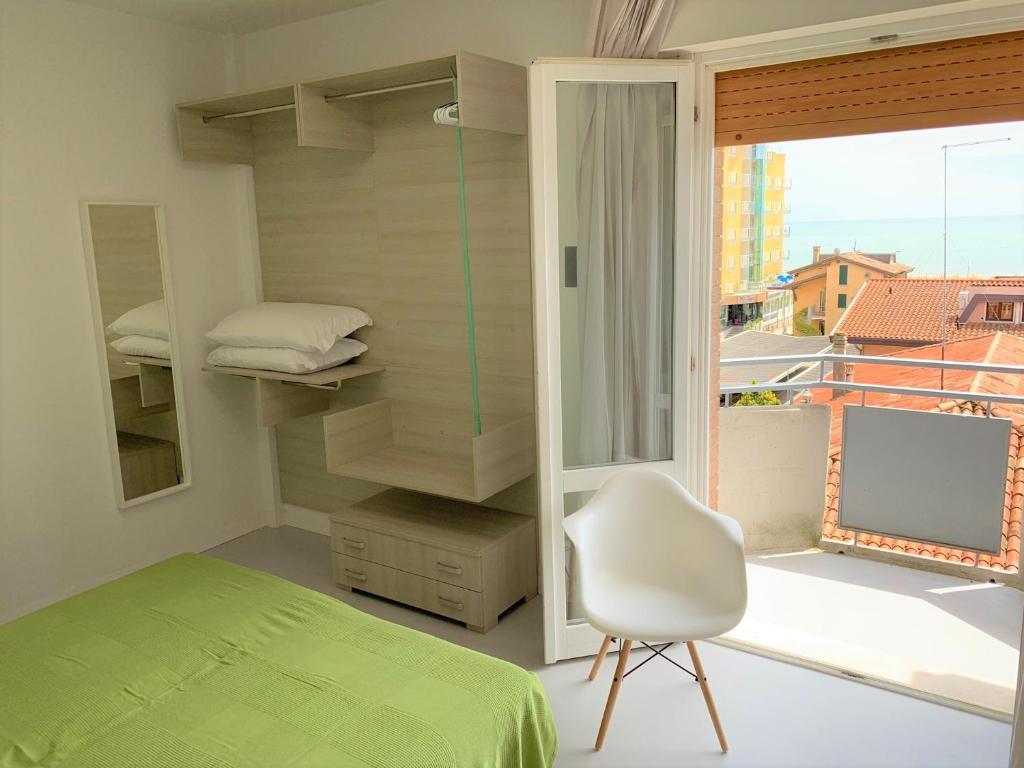 une chambre avec un lit, une chaise et une fenêtre dans l'établissement Hotel & Residence Al Mare, à Lido di Jesolo