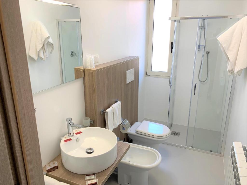 une salle de bain avec un lavabo, des toilettes et une douche dans l'établissement Hotel & Residence Al Mare, à Lido di Jesolo