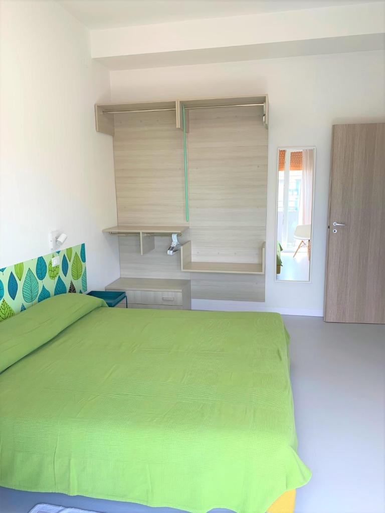 une chambre avec un lit vert et une fenêtre dans l'établissement Hotel & Residence Al Mare, à Lido di Jesolo