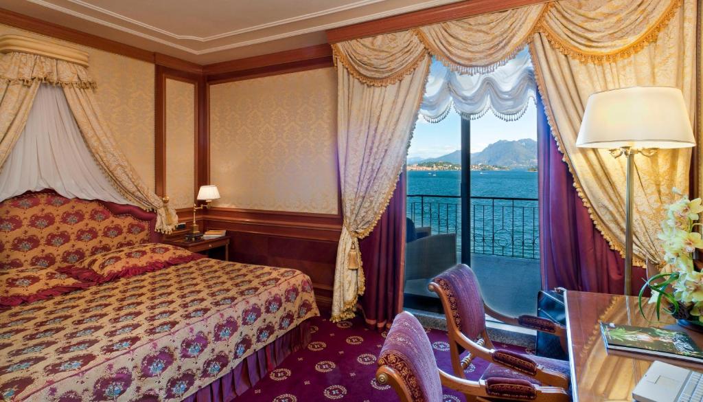 une chambre d'hôtel avec un lit et un balcon dans l'établissement Grand Hotel Dino, à Baveno