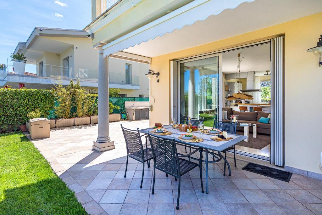 - une table et des chaises sur une terrasse avec une maison dans l'établissement Villa Perla con piscina by Wonderful Italy, à Barcuzzi