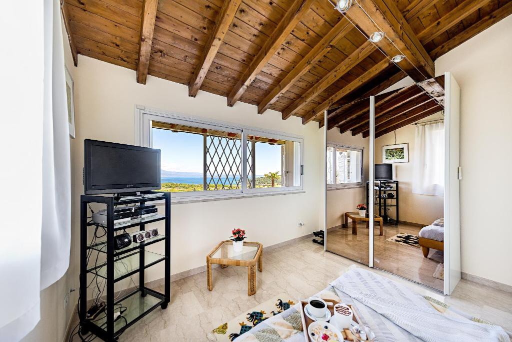 Cette chambre comprend un lit, une télévision et une fenêtre. dans l'établissement Villa Perla con piscina by Wonderful Italy, à Barcuzzi