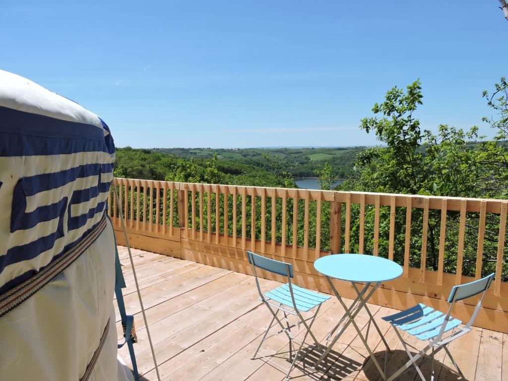 un patio avec une table et des chaises sur une terrasse dans l'établissement Yourte Mongole, à Mont-Roc 1 autre photo