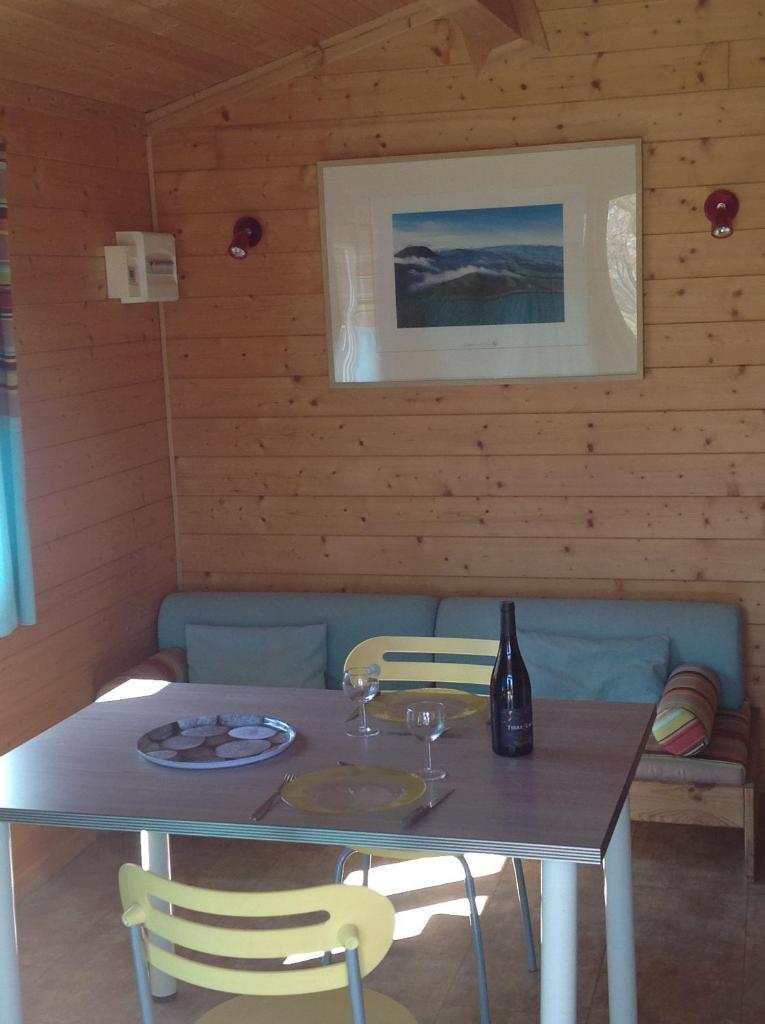 - une table avec 2 chaises et une bouteille de vin dans l'établissement Camping Le Pont d'Allagnon, à Lempdes-sur-Allagnon
